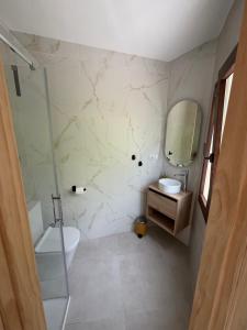 a bathroom with a sink toilet and a mirror at Casa Chica in Cazorla +14 photos