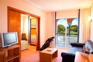 a living room with a couch and a television at Hotel Bonalba Alicante in El Campello