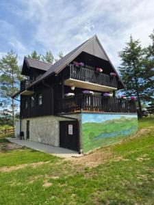 a black house with a balcony and a mural at Danka Riverside House in Livno