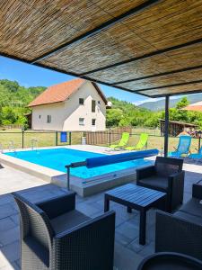 a swimming pool with chairs and a table at Vila Petar Mokra Gora in Mokra Gora