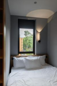 a bedroom with a large bed with a window at Апарт-готель Select in Lviv