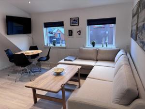 a living room with a couch and a table at Penthouse Apartment with Balcony in City Centre and Private Parking in Tórshavn