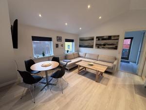a living room with a couch and a table and chairs at Penthouse Apartment with Balcony in City Centre and Private Parking in Tórshavn