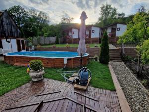 a backyard with a swimming pool and an umbrella at Flori Haus Saschiz in Saschiz
