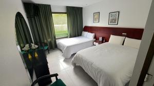a hotel room with two beds and a window at Motel Montecarlo in Teo