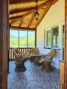 a porch with wicker chairs and a table and windows at Vila Petar Mokra Gora in Mokra Gora
