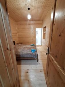 a bedroom in a wooden cabin with a bed in it at Heshklar guest house in Keshkili