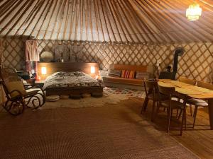 a yurt with a bed and a table and chairs at Káli Jurta in Tapolca