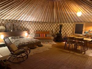 a bedroom with a bed and a table and chairs at Káli Jurta in Tapolca