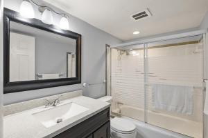 a bathroom with a sink and a toilet and a shower at Shark tooth Condo in Venice