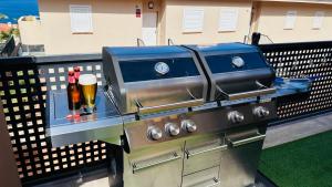 a barbecue grill with a beer bottle on top of it at Ocean Sunset House in Puerto de Santiago