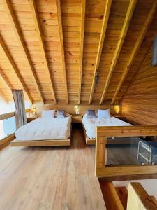 two beds in a room with a wooden ceiling at Cabañas en Zacatlán-Rancho el Mayab in Zacatlán