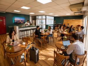 a group of people sitting at tables in a restaurant at Goya Hotel in Buenos Aires