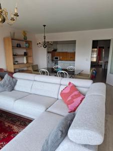 a living room with a white couch with a pink pillow at Appartement Havenzicht Harbor View in Blankenberge