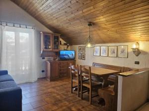 a dining room with a table and a tv at San Rocco Lodge in Livigno