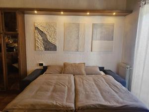 a large bed in a bedroom with paintings on the wall at San Rocco Lodge in Livigno