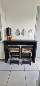 a black table with two mirrors and two chairs at Casa confortável em Tangará in Tangara da Serra
