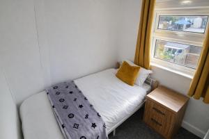 a small bed in a small room with a window at Onyx Place Spacious 3BR Home l Fast London Commute l Parking in North Ockendon