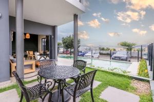 a patio with a table and chairs and a view of a yard at Zoe Lodge in Midrand