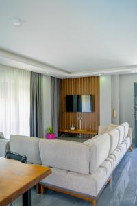 a living room with a couch and a flat screen tv at Türkmen Villa in Belek