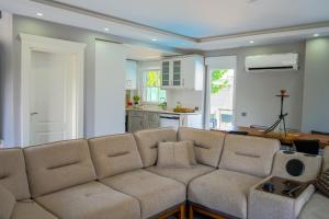 a living room with a couch and a kitchen at Türkmen Villa in Belek