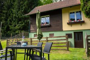 a table with an umbrella in front of a house at Naturidyll Lavantall in Lading
