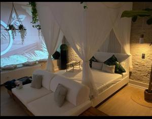 a bedroom with a white bed and a white couch at Luxus Spa Wellness Apartment in Heiligenhaus