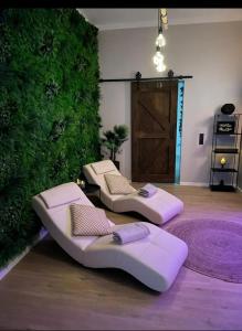 a room with two beds and a green wall at Luxus Spa Wellness Apartment in Heiligenhaus