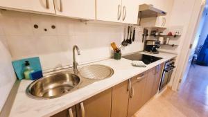a kitchen with a sink and a counter top at Apartamento Oasis Tamarindo Vista Al Mar in Corralejo +18 photos