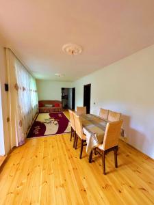 a dining room with a table and chairs and a bedroom at Sweet home in Lerik +1 photo