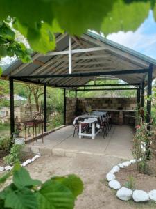 a wooden pavilion with a table and chairs under it at Sweet home in Lerik