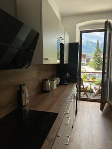 a kitchen with a counter with a view of a patio at City Center Rooms in Mayrhofen
