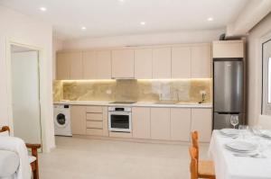 a kitchen with white cabinets and a table and chairs at Villa Shelegar in (( Metoq )) +26 photos
