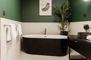 ein Badezimmer mit Badewanne und einer Pflanze in der Unterkunft Boutique rooms Vis Adults only in Vis