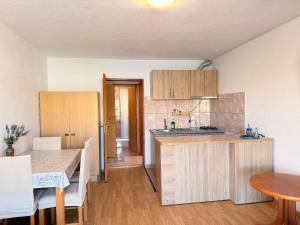 a kitchen with wooden cabinets and a table in a room at Apartments TORO Pag in Pag