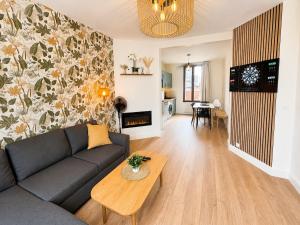 a living room with a couch and a table at Évasion Aubinoise, charmant duplex in Saint-Aubin-lès-Elbeuf