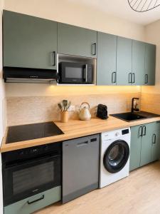 a kitchen with a washer and dryer and a microwave at Évasion Aubinoise, charmant duplex in Saint-Aubin-lès-Elbeuf +16 photos