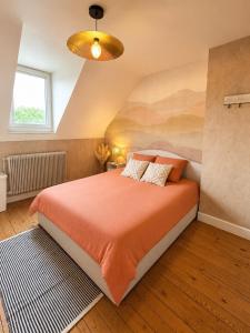 a bedroom with a bed with an orange bedspread at Évasion Aubinoise, charmant duplex in Saint-Aubin-lès-Elbeuf