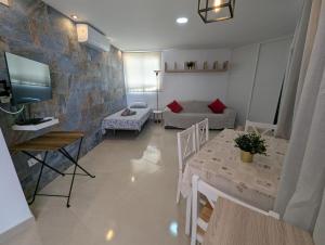 a living room with a couch and a table and a tv at Apartamento Studio Anau k&L- Playa del inglés - Yumbo in Playa del Ingles