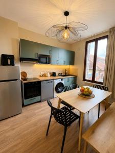 a kitchen with a table and a dining room at Évasion Aubinoise, charmant duplex in Saint-Aubin-lès-Elbeuf
