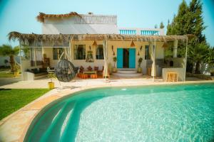 a villa with a swimming pool in front of a house at Villa Aloe Vera Privée in Essaouira