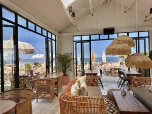 a restaurant with tables and chairs and a view of the ocean at The Lighthouse Cabin in Noordwijk