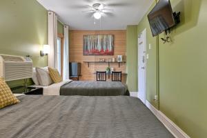 a hotel room with two beds and a flat screen tv at Pepperell Place Inn Inc. in St. Peter's