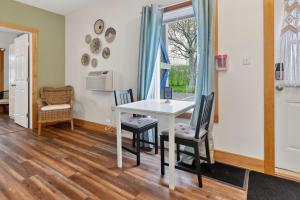 a dining room with a white table and chairs at Pepperell Place Inn Inc. in St. Peter's
