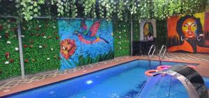 a swimming pool with a painting on the wall at Charles Stainless Hotels in Abakaliki