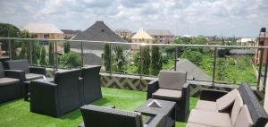 a balcony with chairs and a view of a city at Charles Stainless Hotels in Abakaliki