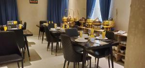 a dining room with black tables and black chairs at Charles Stainless Hotels in Abakaliki