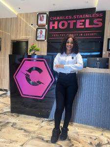 a woman standing next to a counter with a sign at Charles Stainless Hotels in Abakaliki +8 photos