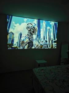a room with a tv screen with a view of a city at Suíte cine centro in Garanhuns