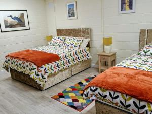 a bedroom with two beds and a table with a lamp at Radharc an Hook Estuary Bliss in Duncannon